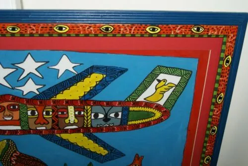 RARE UNIQUE COLORFUL  FOLK ART PAINTING PAPUA NEW GUINEA HUMOROUS ARTIST: TRIBAL WARRIORS TRAVELLING BY AIRPLANE & FRAMED IN SIGNED HAND PAINTED FRAME TO MATCH THE ART DESIGNER COLLECTOR WALL CARTOON  ART  26 1/2” by 23 1/2” HUGE DFP8